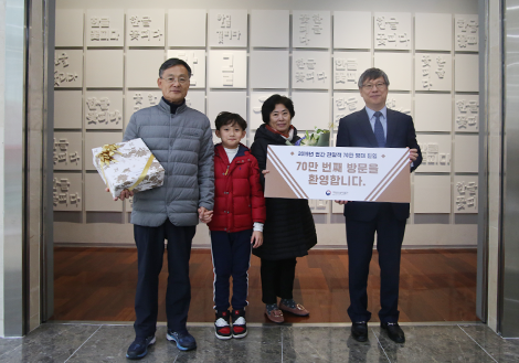 할아버지, 손자, 할머니, 심동섭 관장이 ‘70만 번째 방문을 환영합니다’란 패널을 들고 기념촬영 포즈를 취하고 있다.