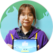 지구 모양 배경 안에 보라색 옷을 입은 에누마코리아의 김은파 기획자가 태블릿을 들고 정면을 바라보고 있다. 