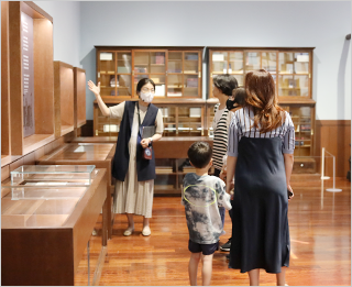 한글 잡지 『어린이』의 창간 100주년을 기념하여 국립한글박물관에서 열리고 있는 기획특별전 <어린이 나라> 현장 사진이다. 하얀 벽 왼쪽엔 초록색 상의와 빨간색 하의를 입은 천사가 그려져 있으며, 오른쪽엔 『어린이』 잡지들이 전시장 안에 보관돼 있다.