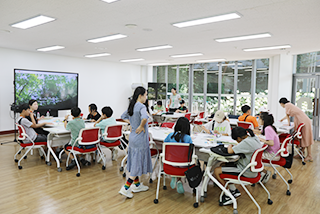 기획 전시 <어린이 나라>와 연계하여 국립한글박물관과 한국방정환재단이 공동으로 기획한 ‘잡지 『어린이』 특집호 만들기’ 현장 사진이다. 많은 어린이가 조별로 테이블에 앉아있다.