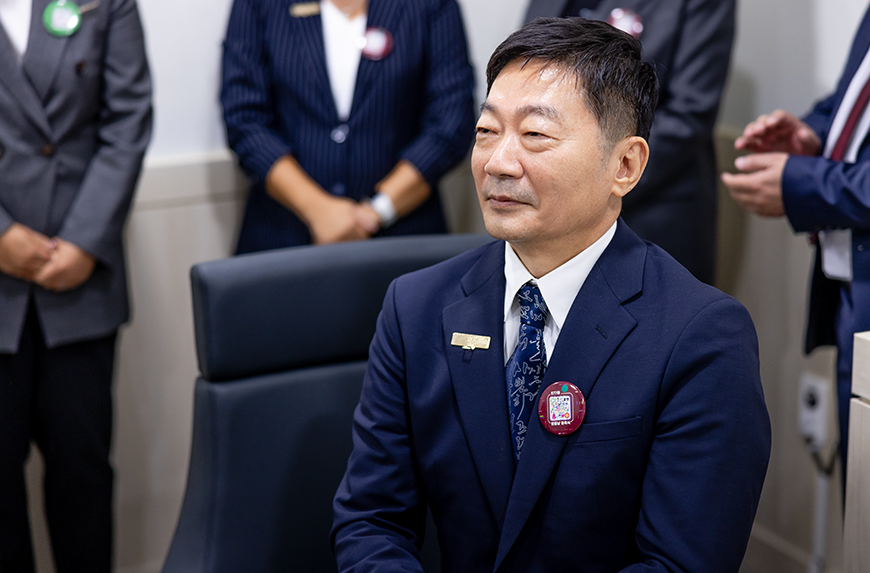 지난해 한글날 경축식에서 정장을 입은 김중섭 교수가 자리에 앉아 왼쪽을 바라보고 있다. 그의 뒤엔 여러 사람이 서 있다.