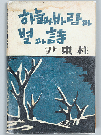 파란색으로 ‘하늘과 바람과 별과 시’라고 적힌 책이 있다. 제목의 아래에는 한자로 ‘윤동주’라고 쓰여 있다.