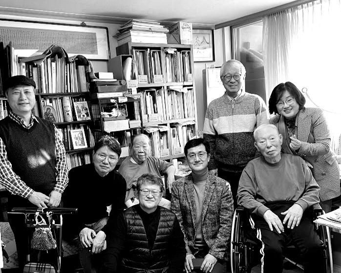 새해에 제자들이 강신항 교수 댁을 방문해 함께 찍은 사진이다. 책이 가득 꽂혀있는 책장 앞에 휠체어를 타고 앉아 있는 강신항 교수가 있다. 그의 주변을 제자들과 아내가 둘러싸고 있다.